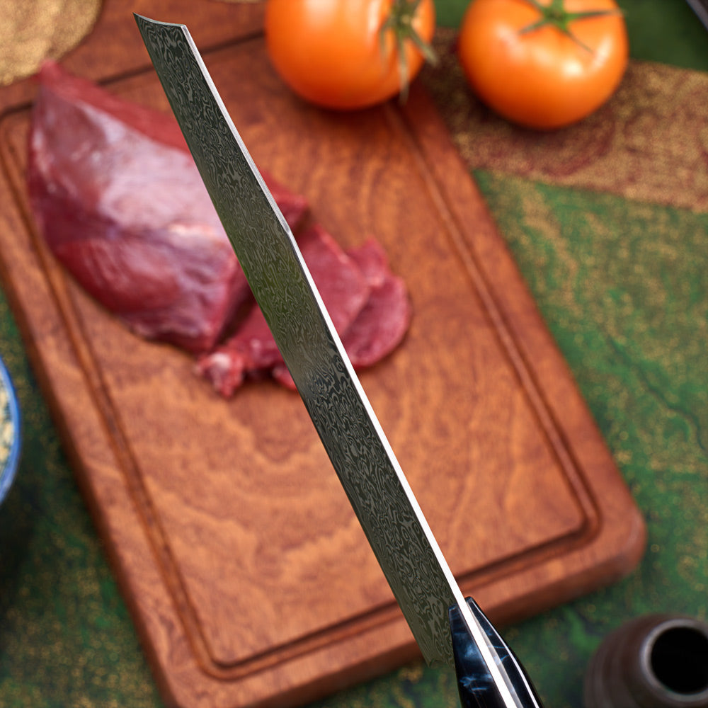 A Japanese-style kitchen knife with a Damascus steel blade is shown slicing raw red meat on a wooden cutting board, with tomatoes in the background.