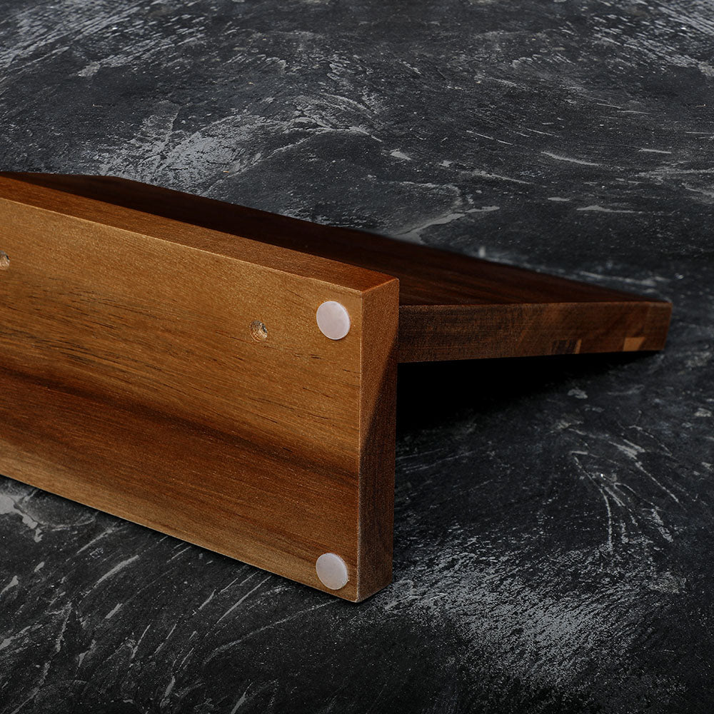 Wooden cutting board on a dark marble surface, anti-slip base